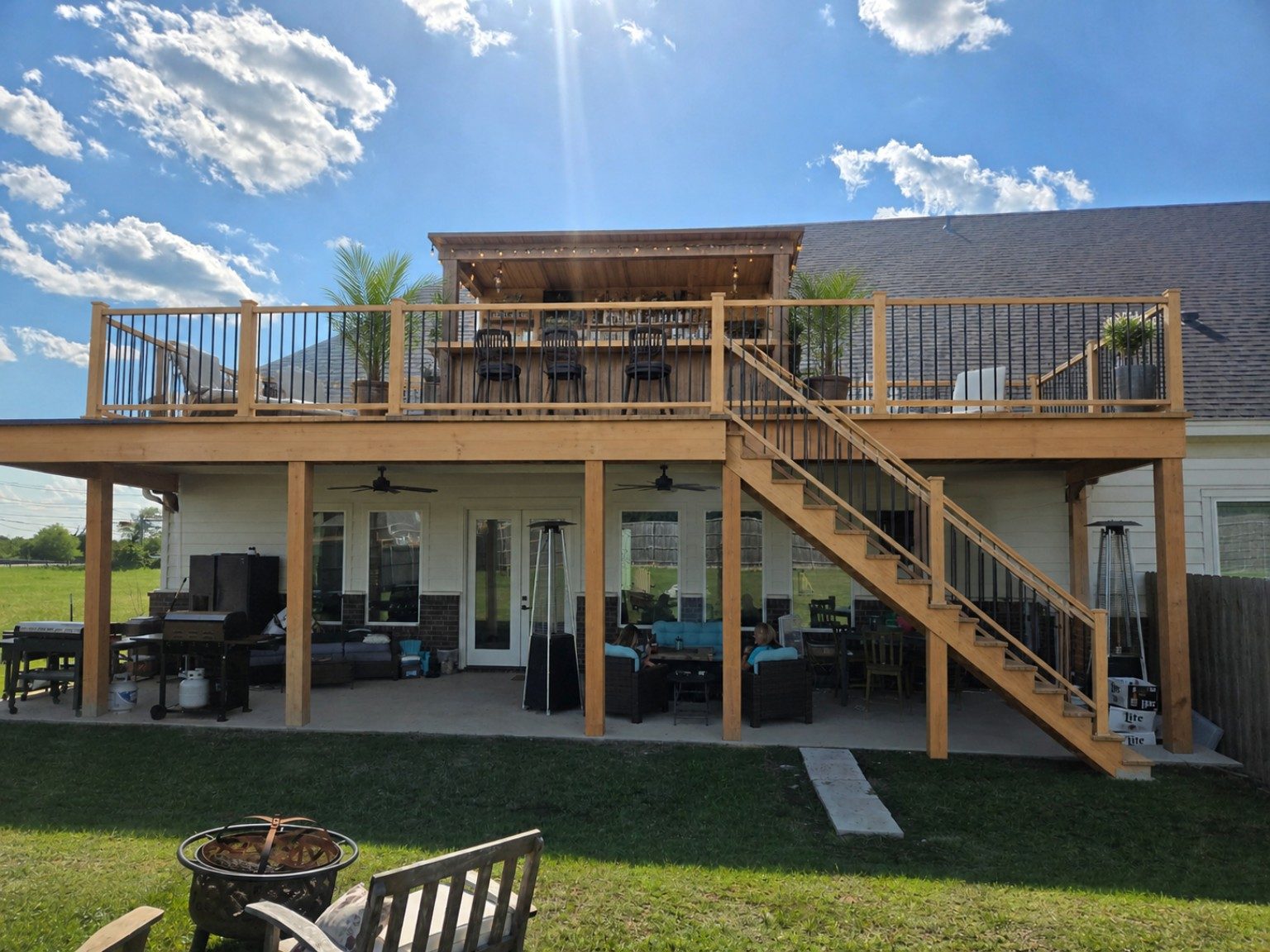 After — two-story custom deck with covered patio, bar and firepit built over the same patio